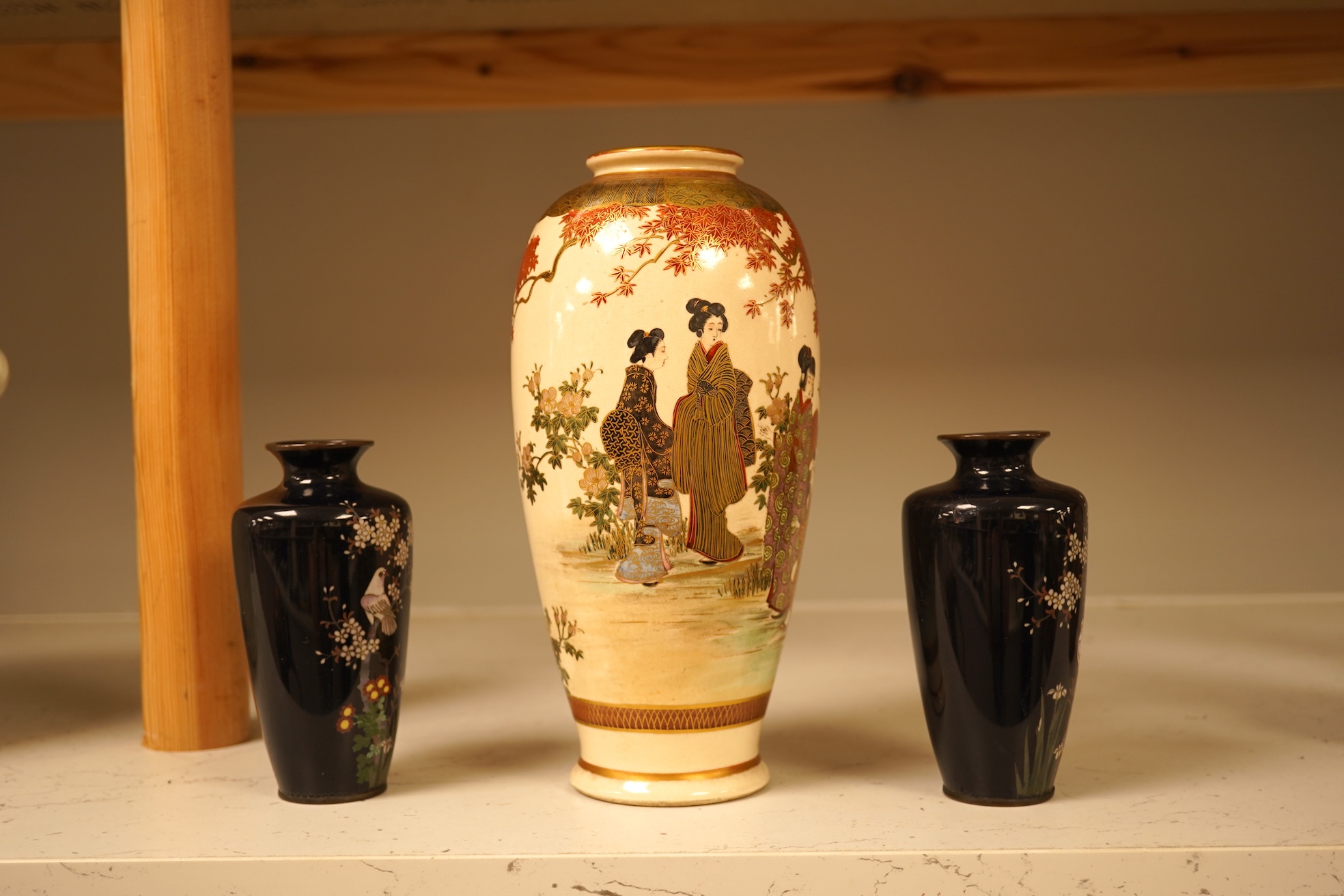 A Japanese figural satsuma vase and a pair of small black cloisonné enamel vases, Satsuma 21.5cm high